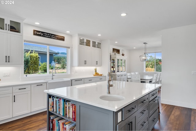 kitchen featuring sink, gray cabinetry, a kitchen island with sink, white cabinetry, and dark hardwood / wood-style floors