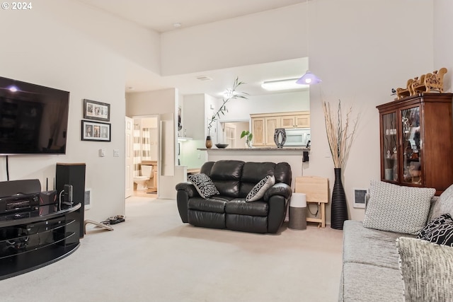 living room with a high ceiling and carpet floors