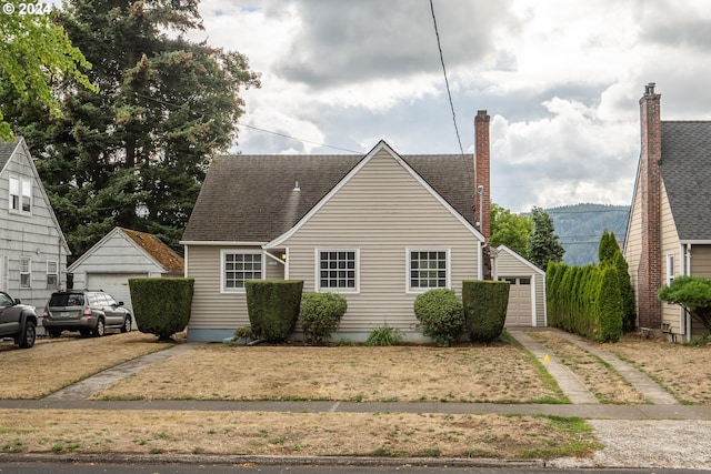 bungalow-style home with a garage and an outbuilding