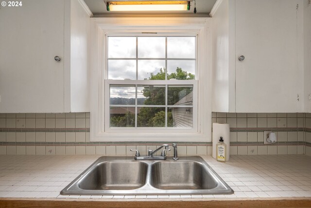 kitchen featuring sink, decorative backsplash, and a healthy amount of sunlight