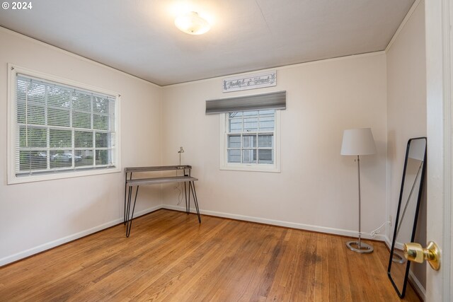 interior space with wood-type flooring and crown molding