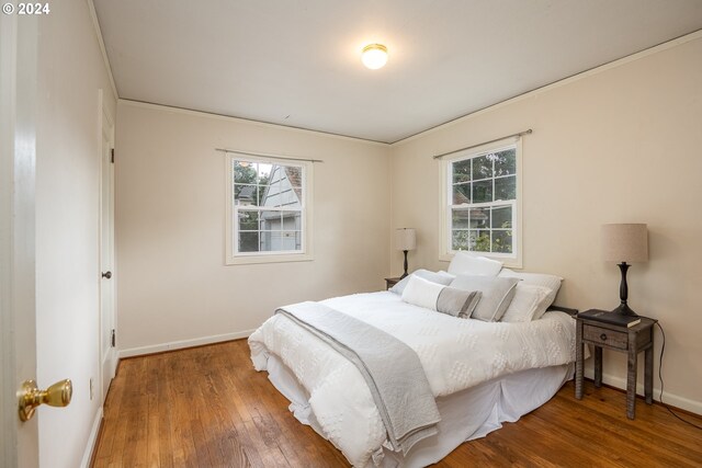 bedroom with wood-type flooring and crown molding