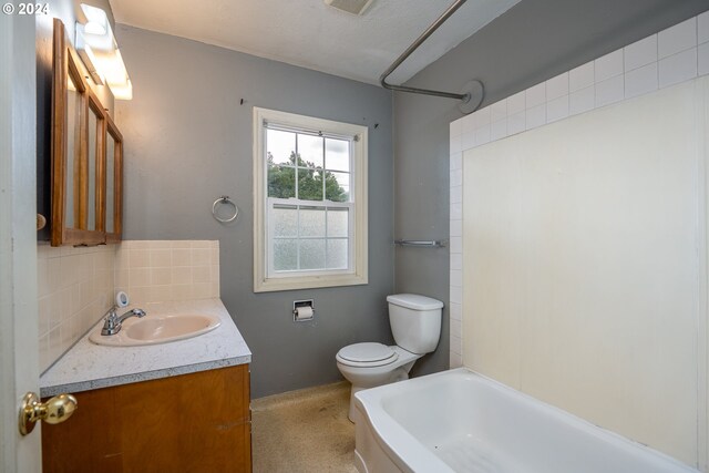 bathroom with a textured ceiling, tasteful backsplash, vanity, and toilet