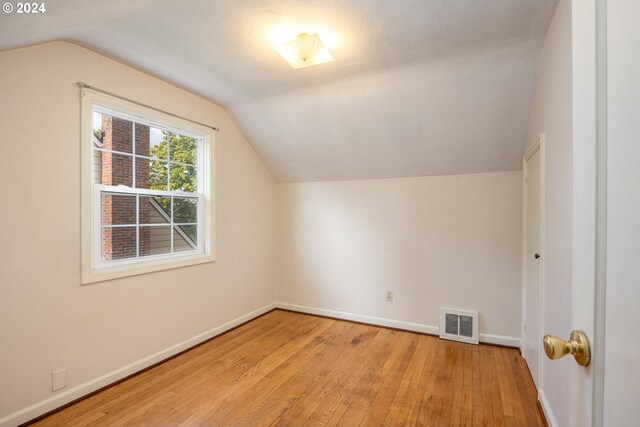 bonus room with light hardwood / wood-style flooring and lofted ceiling