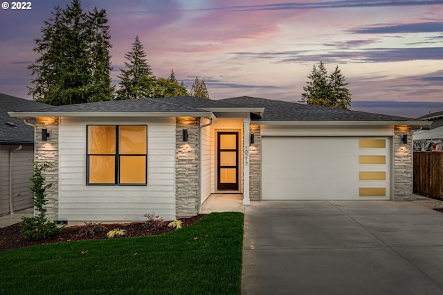 view of front of property with a garage and a yard