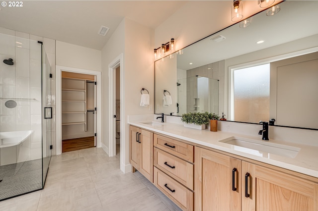 bathroom featuring tile patterned floors, a shower with door, and vanity