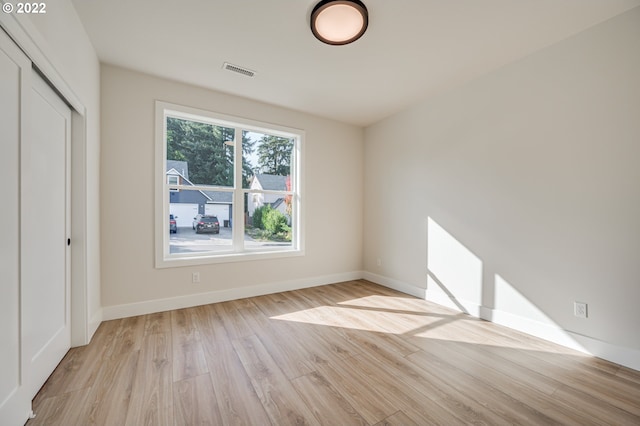 unfurnished bedroom with light hardwood / wood-style flooring and a closet