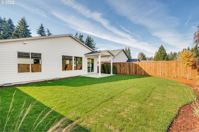 rear view of property featuring a lawn and a patio area