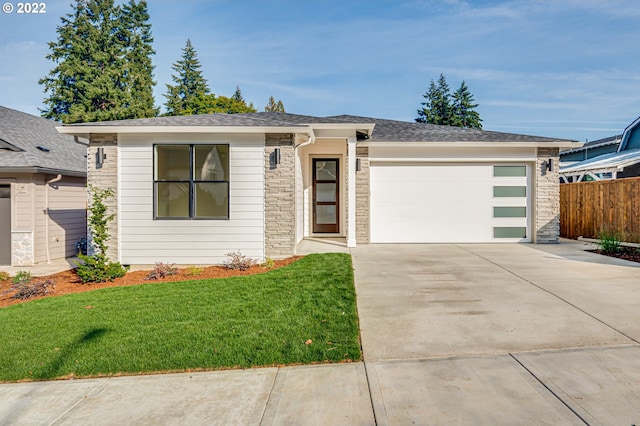 view of front of house featuring a garage and a front lawn