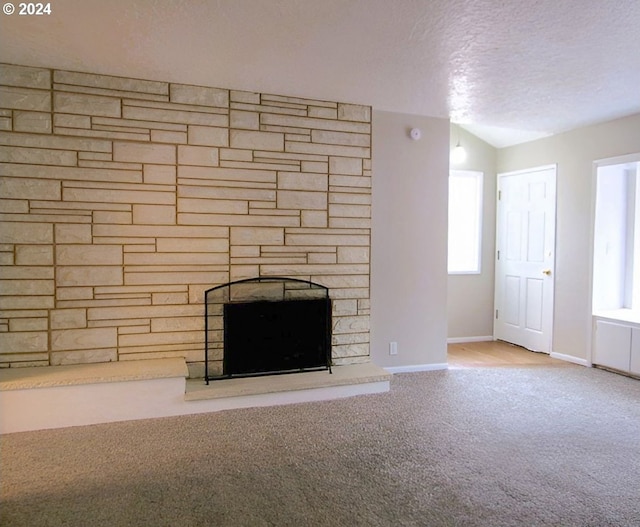 interior details with a fireplace, a textured ceiling, and carpet flooring