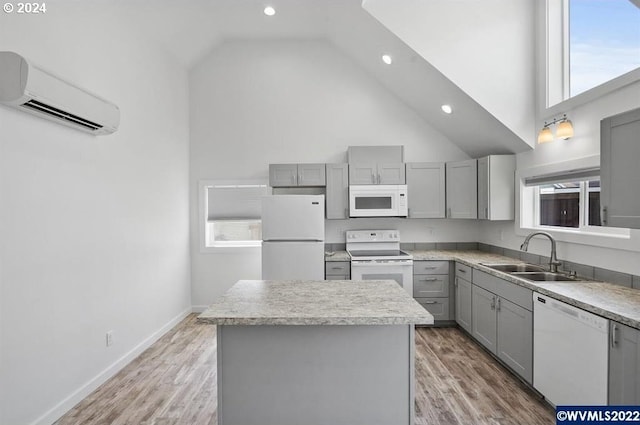 kitchen with sink, a wall unit AC, high vaulted ceiling, white appliances, and a center island