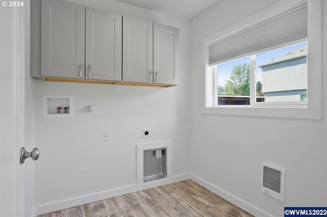 clothes washing area featuring hookup for an electric dryer, light hardwood / wood-style floors, cabinets, heating unit, and hookup for a washing machine