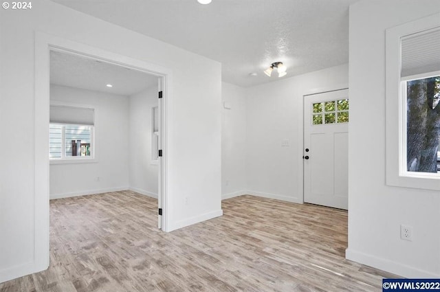 foyer with light hardwood / wood-style floors and a textured ceiling