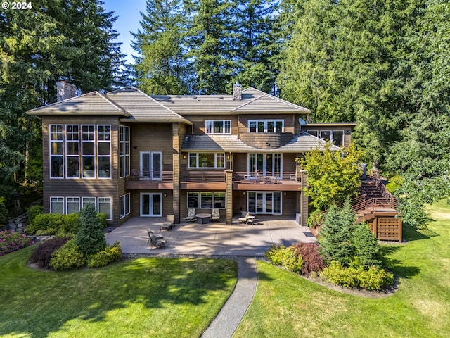 rear view of house with a deck, a yard, and a patio