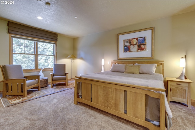 bedroom with a textured ceiling and light colored carpet