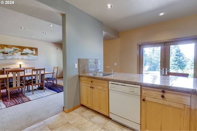 kitchen featuring a sink, light brown cabinets, light carpet, and dishwasher