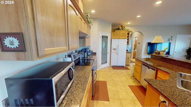 kitchen featuring light brown cabinets, under cabinet range hood, recessed lighting, stainless steel appliances, and arched walkways