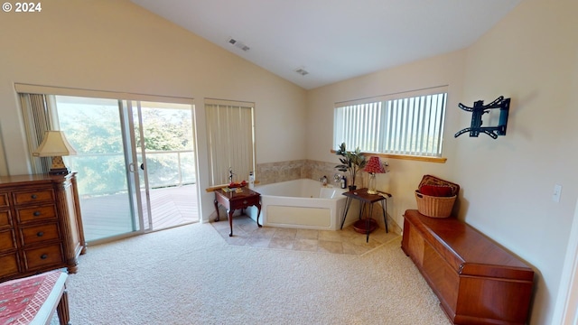 bathroom with visible vents, lofted ceiling, plenty of natural light, and a garden tub