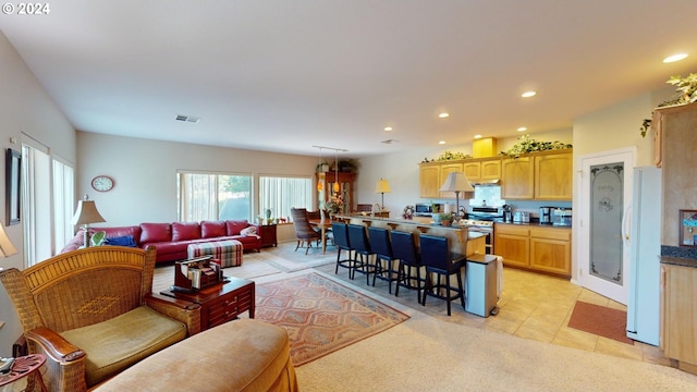 living room featuring light tile patterned flooring, recessed lighting, and visible vents