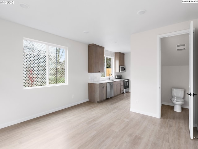 interior space featuring tasteful backsplash, toilet, vanity, and wood-type flooring