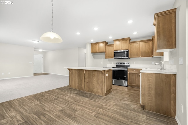 kitchen featuring brown cabinets, appliances with stainless steel finishes, light countertops, and open floor plan