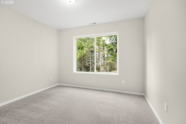 carpeted empty room with visible vents and baseboards