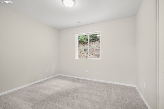 carpeted spare room featuring visible vents and baseboards