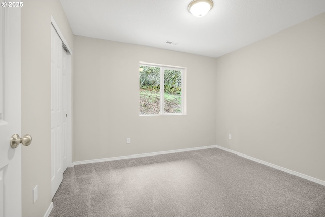 unfurnished bedroom with a closet, carpet, visible vents, and baseboards