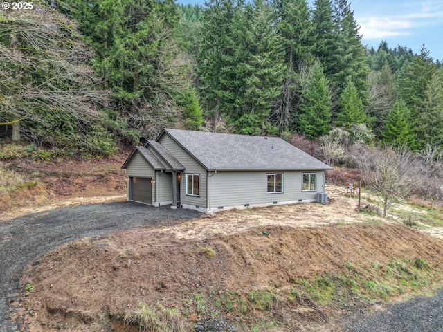 view of front of property featuring driveway, a garage, central AC unit, roof with shingles, and crawl space