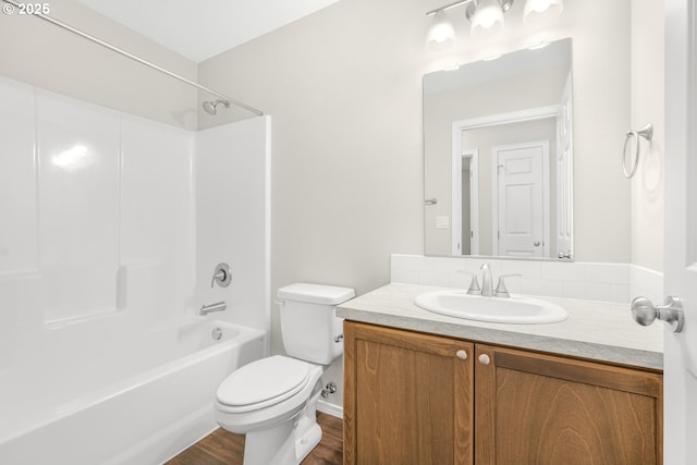 bathroom featuring wood finished floors, shower / bath combination, vanity, and toilet