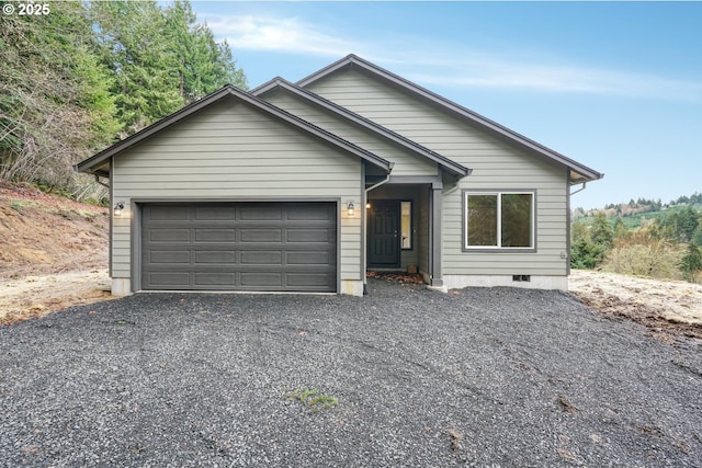 ranch-style home featuring crawl space, driveway, and an attached garage