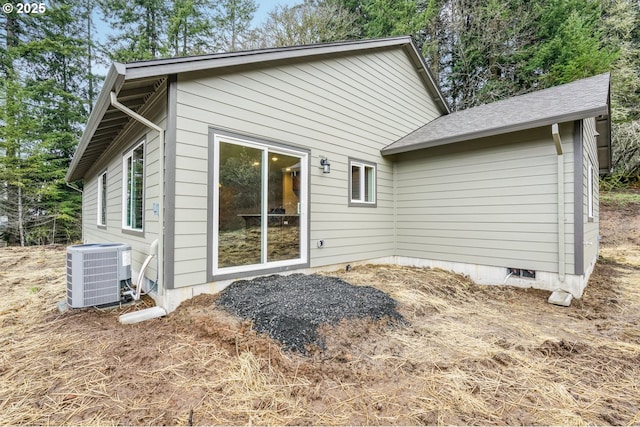 back of property with central air condition unit and crawl space