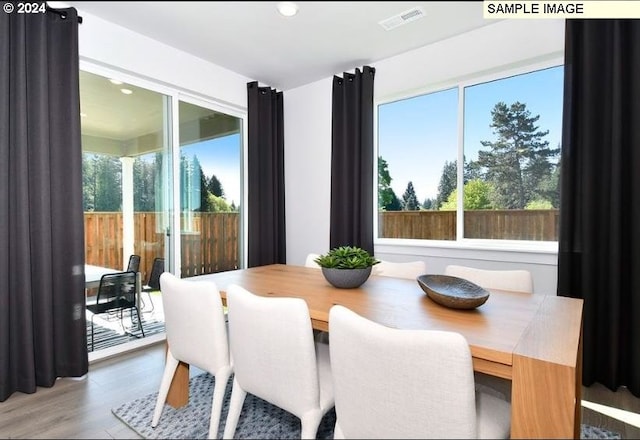 dining space with wood-type flooring