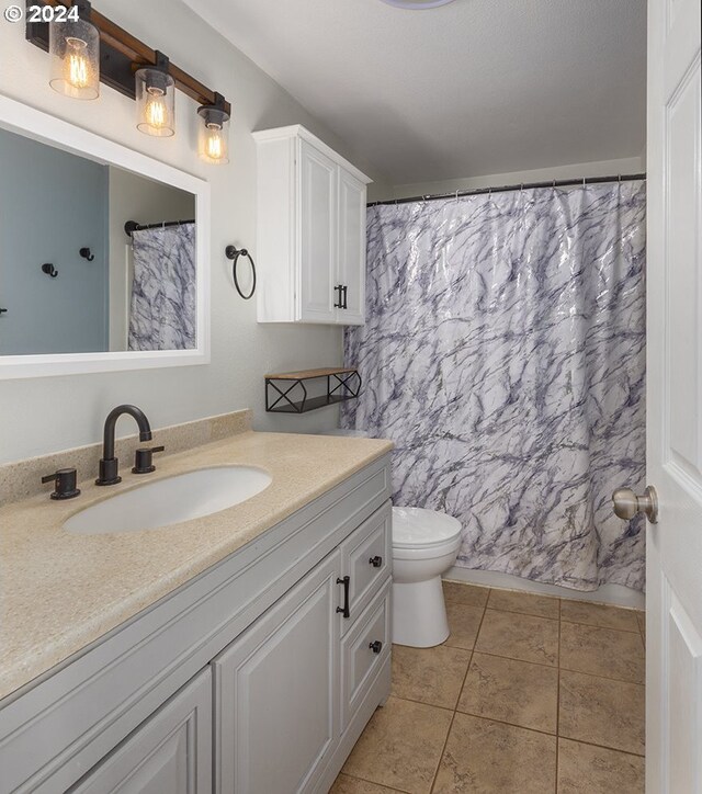 bathroom featuring tile patterned floors, vanity, toilet, and a shower with curtain