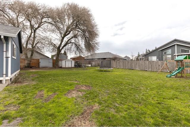 view of yard featuring a playground, a storage shed, and a trampoline