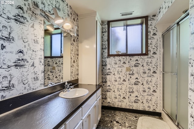 bathroom with vanity and a shower with shower door