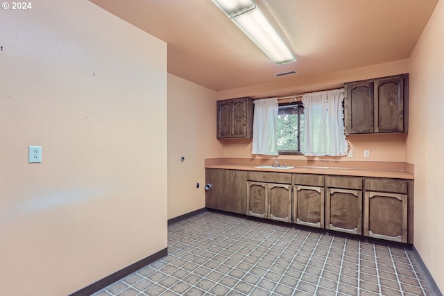 kitchen with dark brown cabinetry and sink