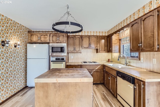 kitchen with light wood-type flooring, a kitchen island, butcher block counters, sink, and appliances with stainless steel finishes