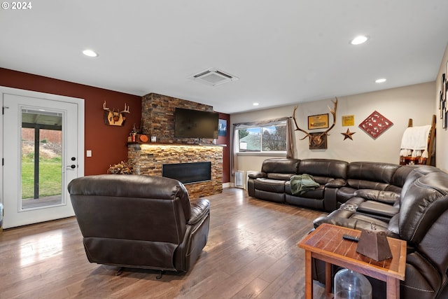 living room featuring visible vents, recessed lighting, a stone fireplace, and hardwood / wood-style flooring