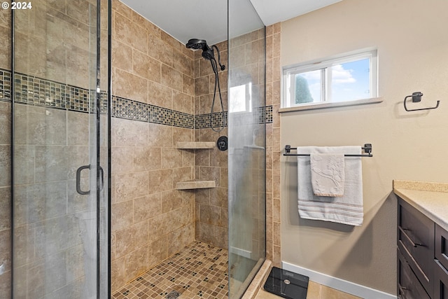 full bathroom featuring vanity, baseboards, and a stall shower