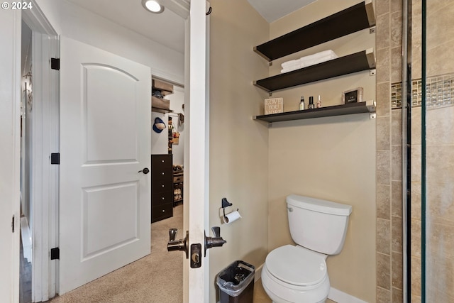 bathroom with a shower with door and toilet