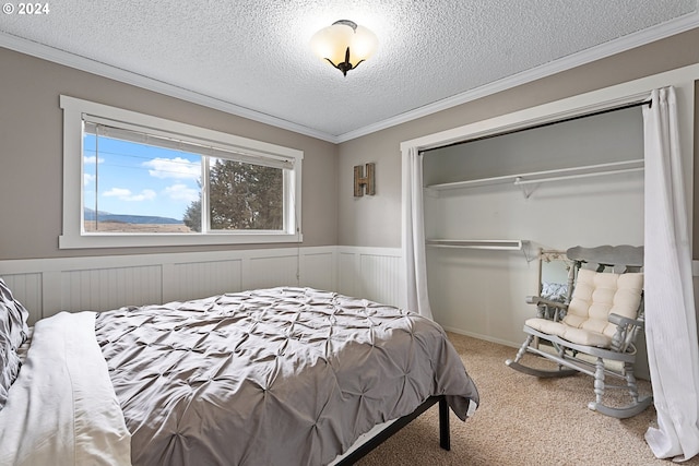 bedroom featuring a closet, ornamental molding, a textured ceiling, and carpet