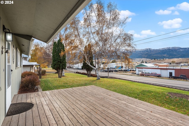 wooden deck featuring a yard and a mountain view