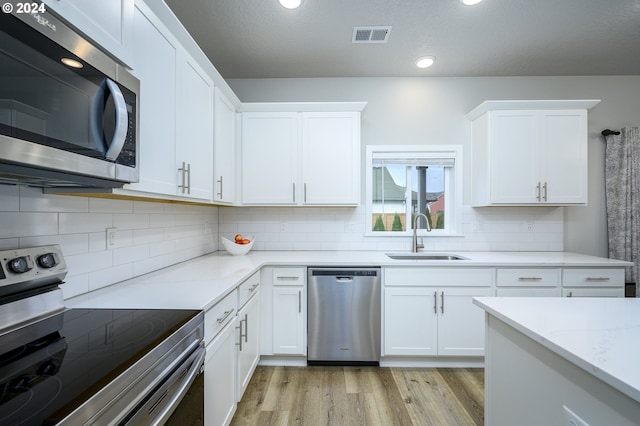 kitchen with white cabinetry, sink, and appliances with stainless steel finishes