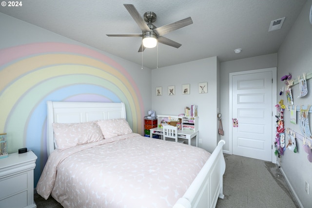 bedroom featuring a textured ceiling, light colored carpet, and ceiling fan