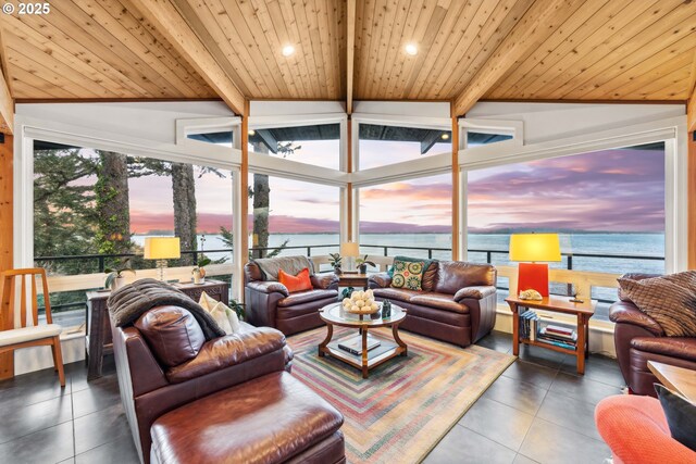 tiled living room with vaulted ceiling with beams, a water view, and a wealth of natural light