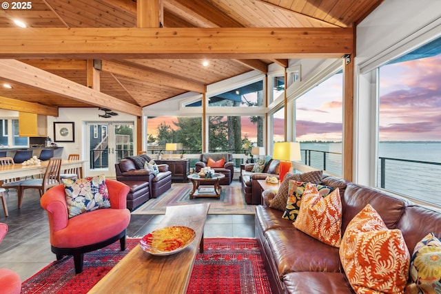 living area with tile patterned floors, a water view, wood ceiling, and vaulted ceiling with beams