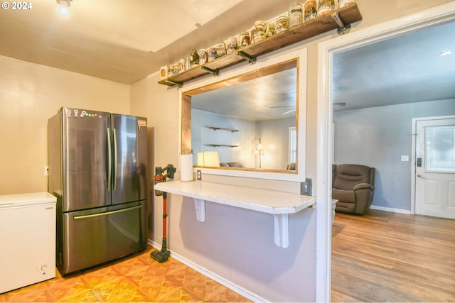 kitchen with light hardwood / wood-style floors, stainless steel fridge, and fridge