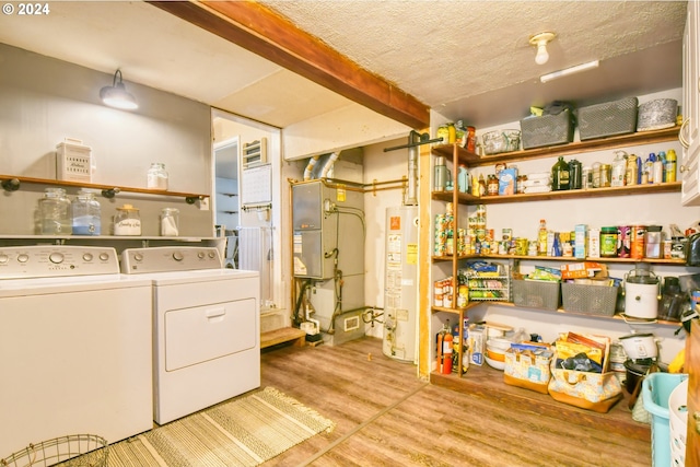 laundry area featuring light hardwood / wood-style floors, a textured ceiling, gas water heater, and independent washer and dryer