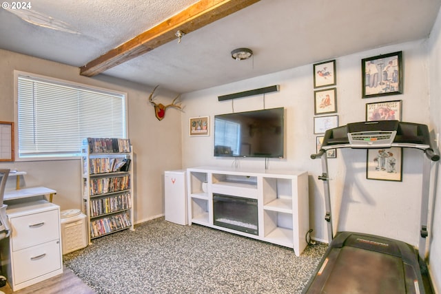 exercise area with carpet flooring and a textured ceiling